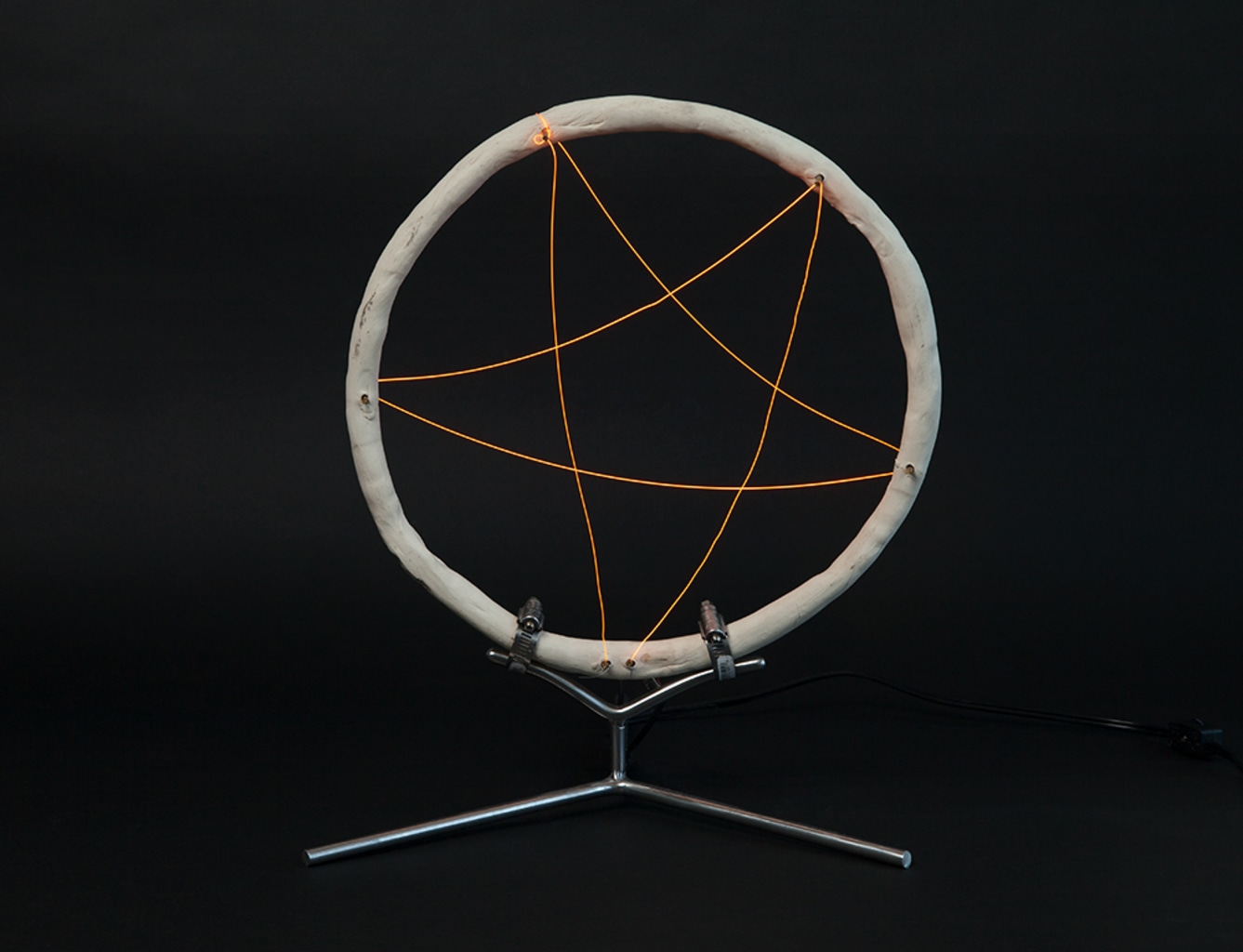 ceramic ring with red hot toaster wire threaded into pentagram shape held by steel base.