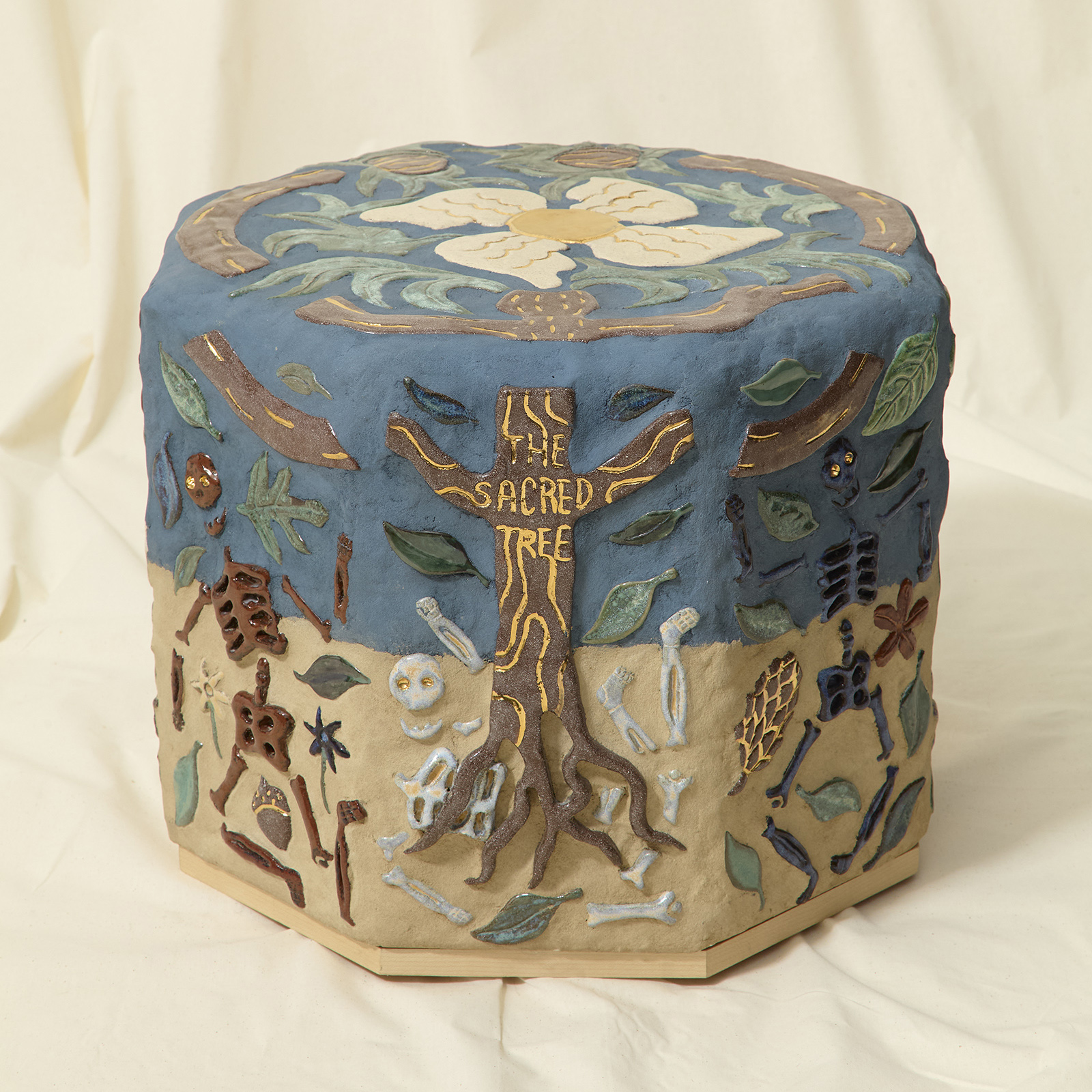 ceramic side table made of figurative tiles depicting dancing skeletons under a tree with leaves and flowers