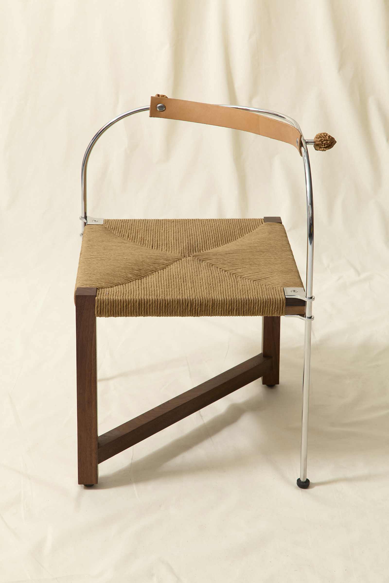 chair made from walnut wood, stainless steel, rush seat, natural tan leather and two walnuts