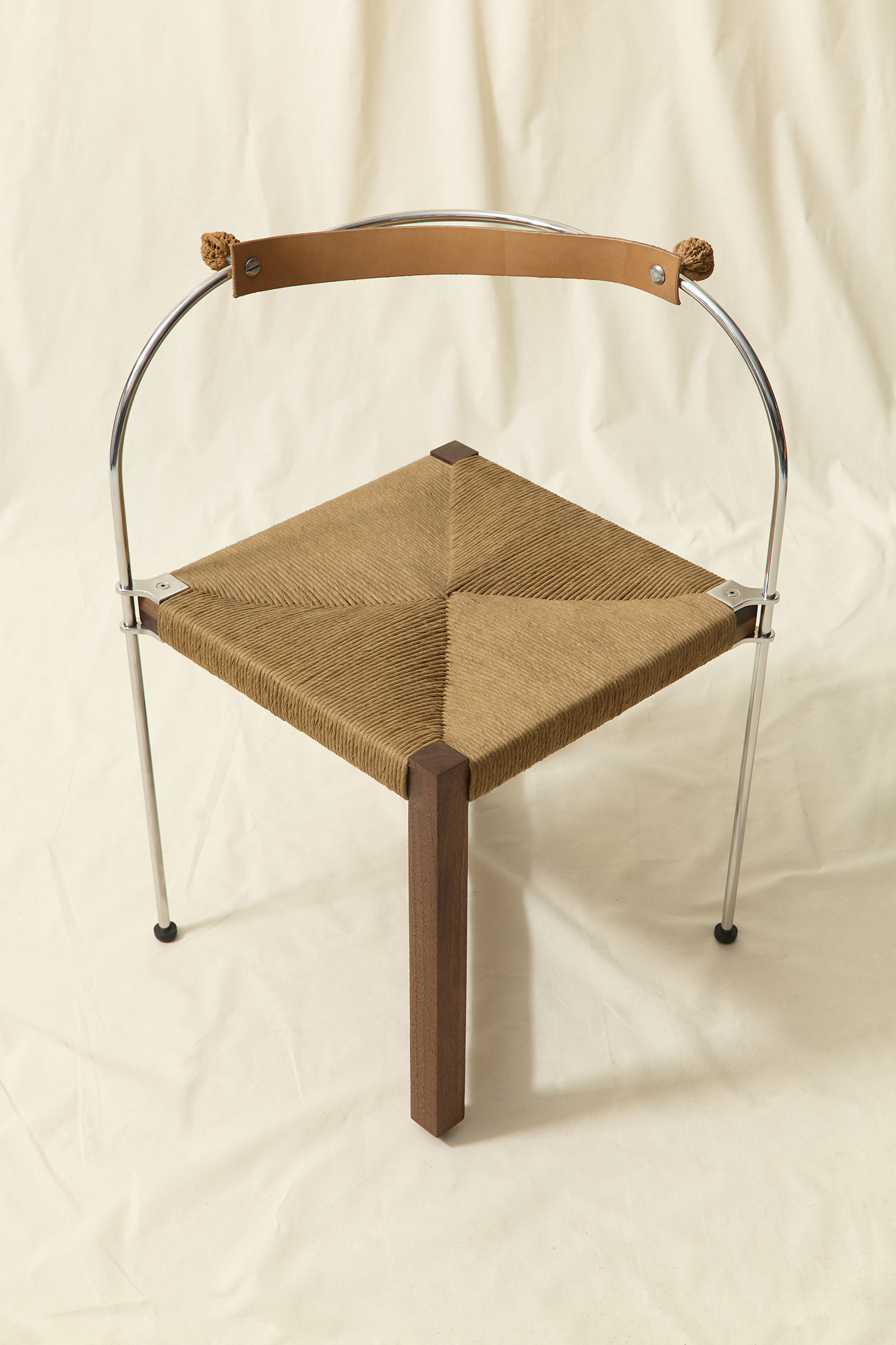 chair made from walnut wood, stainless steel, rush seat, natural tan leather and two walnuts