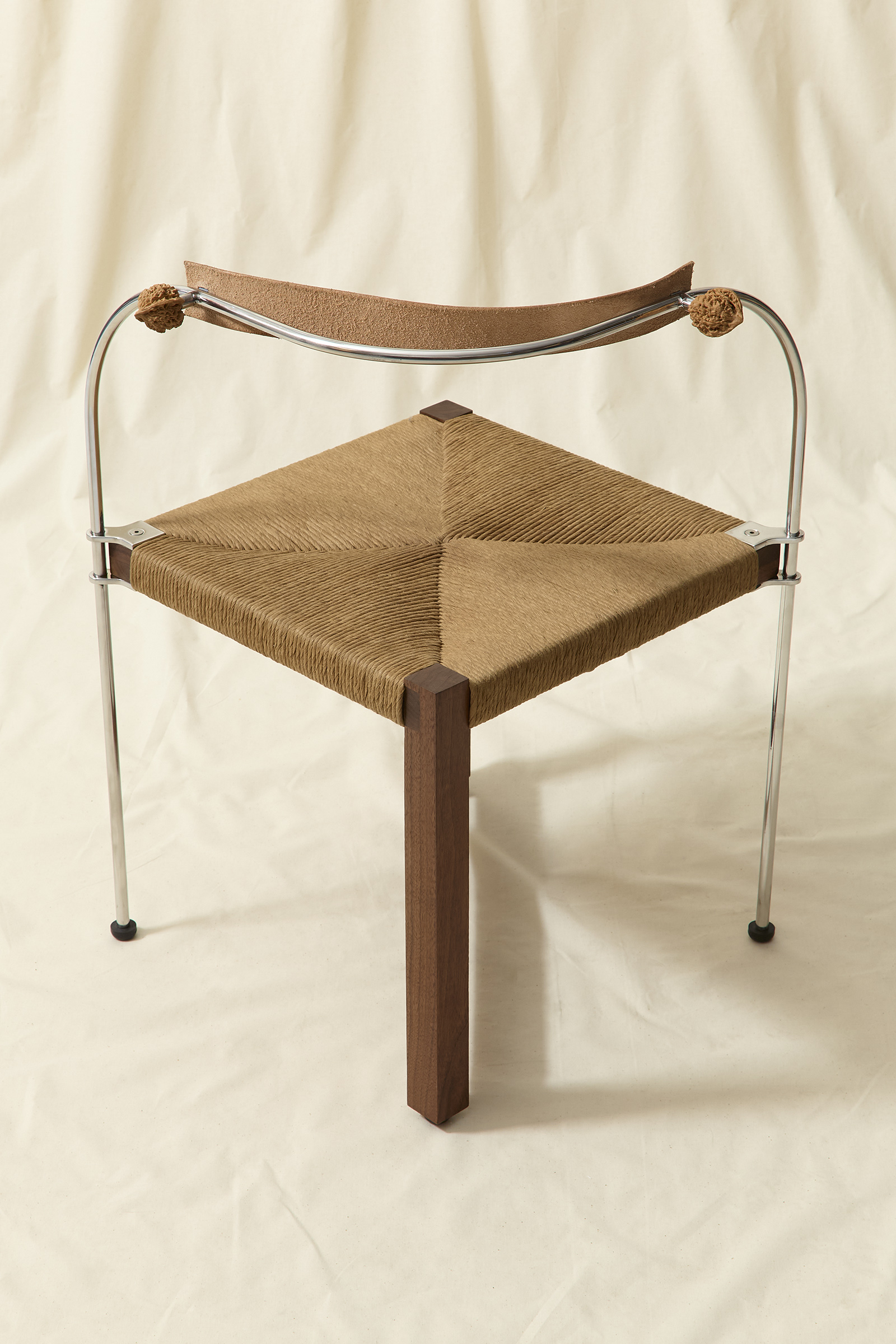 chair made from walnut wood, stainless steel, rush seat, natural tan leather and two walnuts