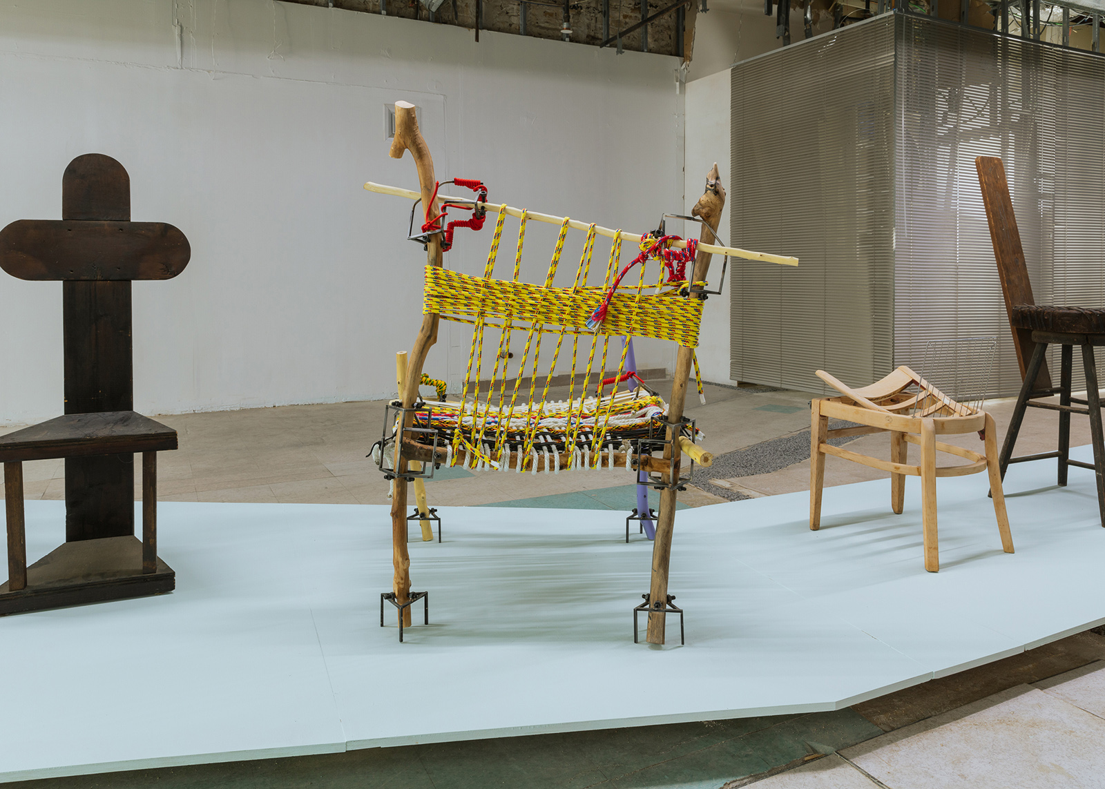 four chairs made of refuse on a platform in an industrial room