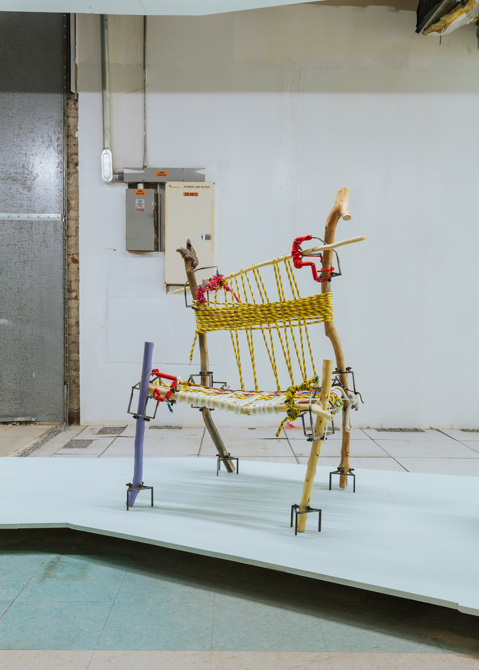 chair made of sticks and rope in an industrial room