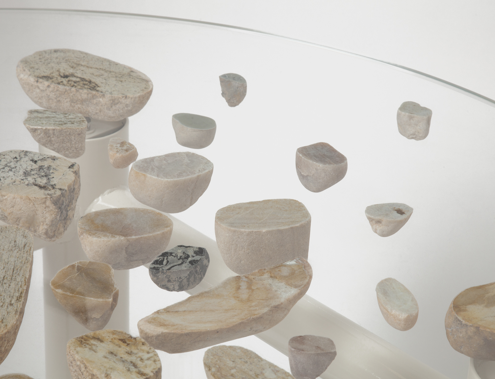 close up of round glass floating stone table with white base.