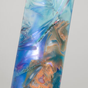 close up of mixed swirls of resin with various material inlays, blue tones base with peach and pink swirls.