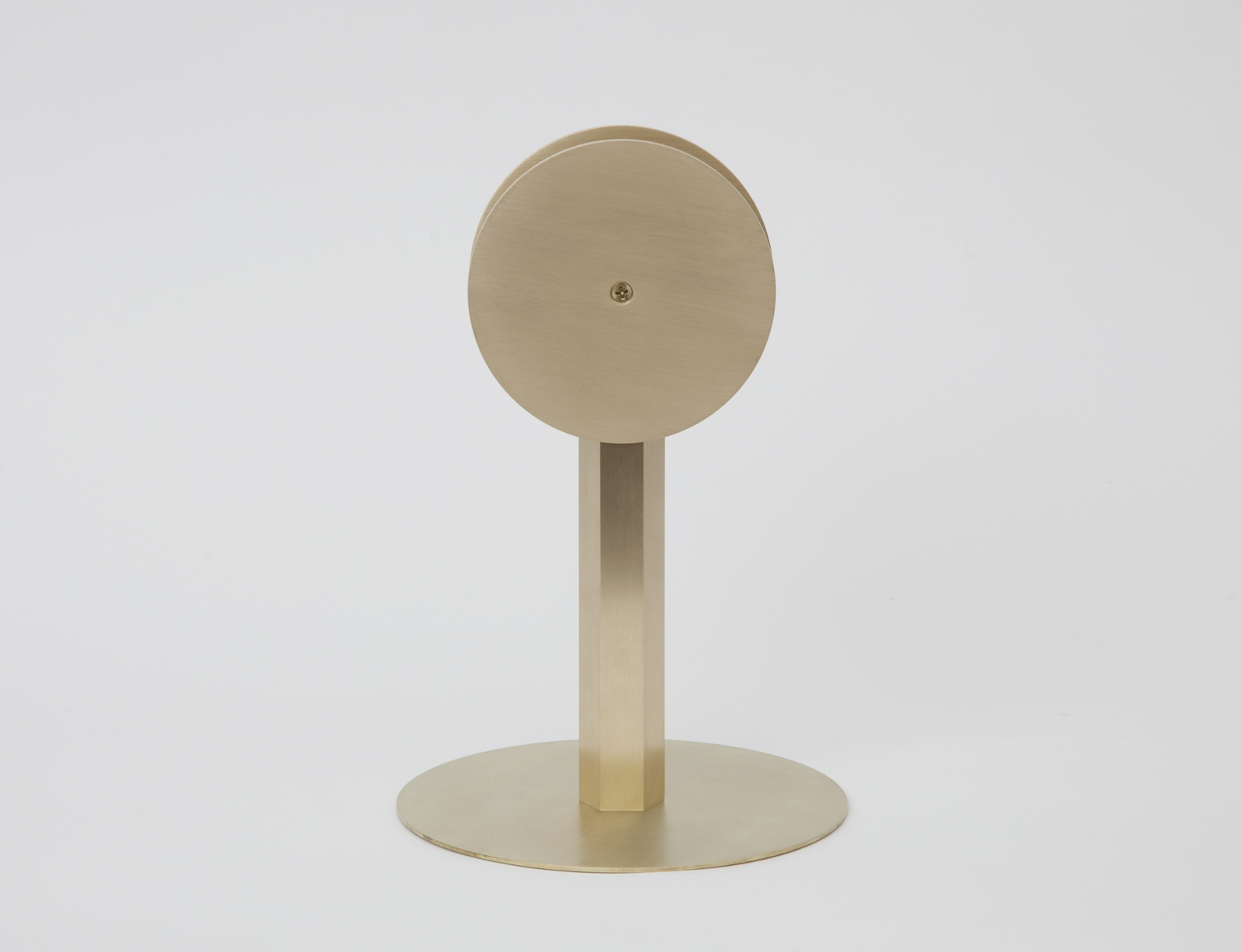 side view of brass circular disk on stand with round base.