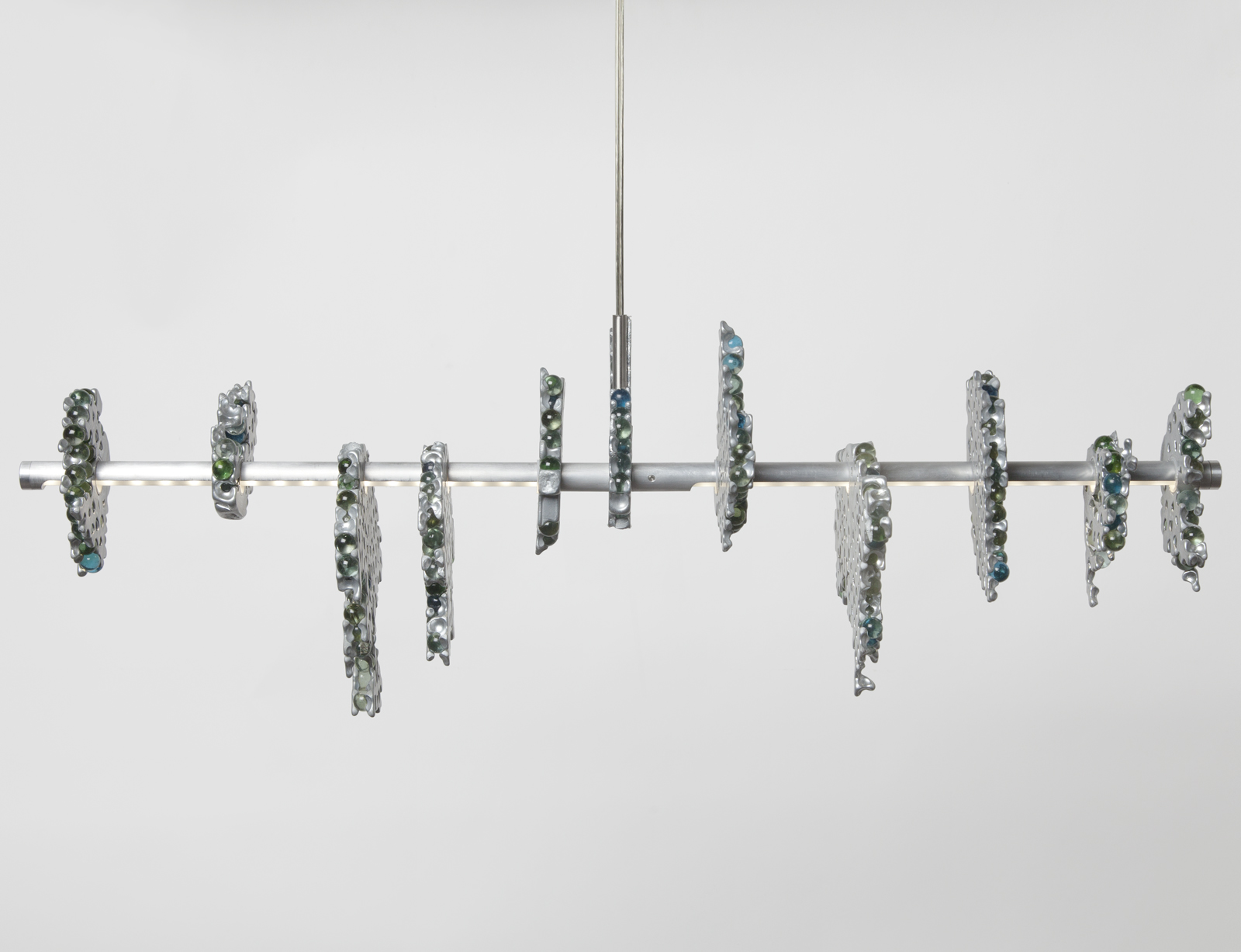 front view of hanging light consisting of a main horizontal LED strip with glass marble clusters held together in aluminum chunks.