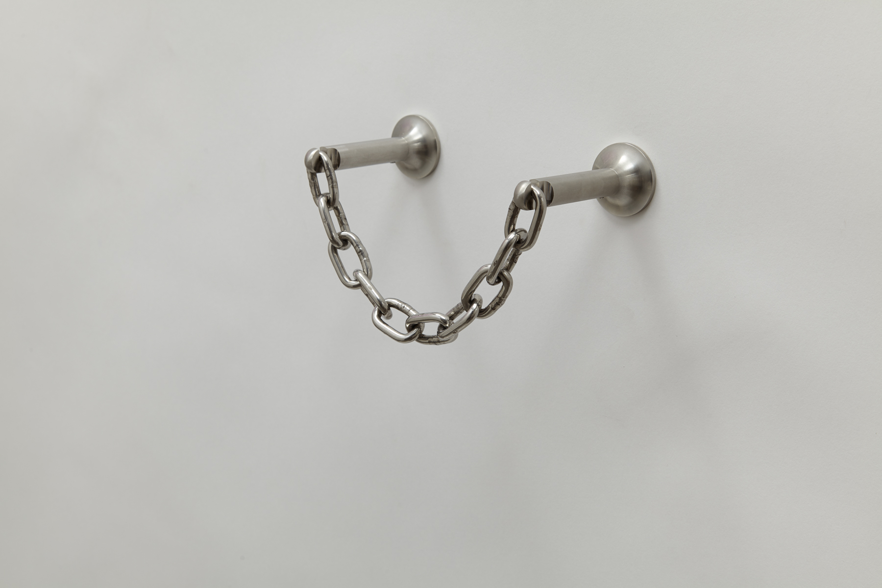 side view of wall mounted toilet paper holder made of chain connected by two steel rods.