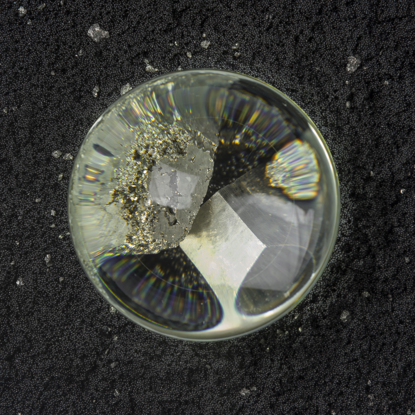 close up of illuminated glass lens magnifying pyrite in cool light