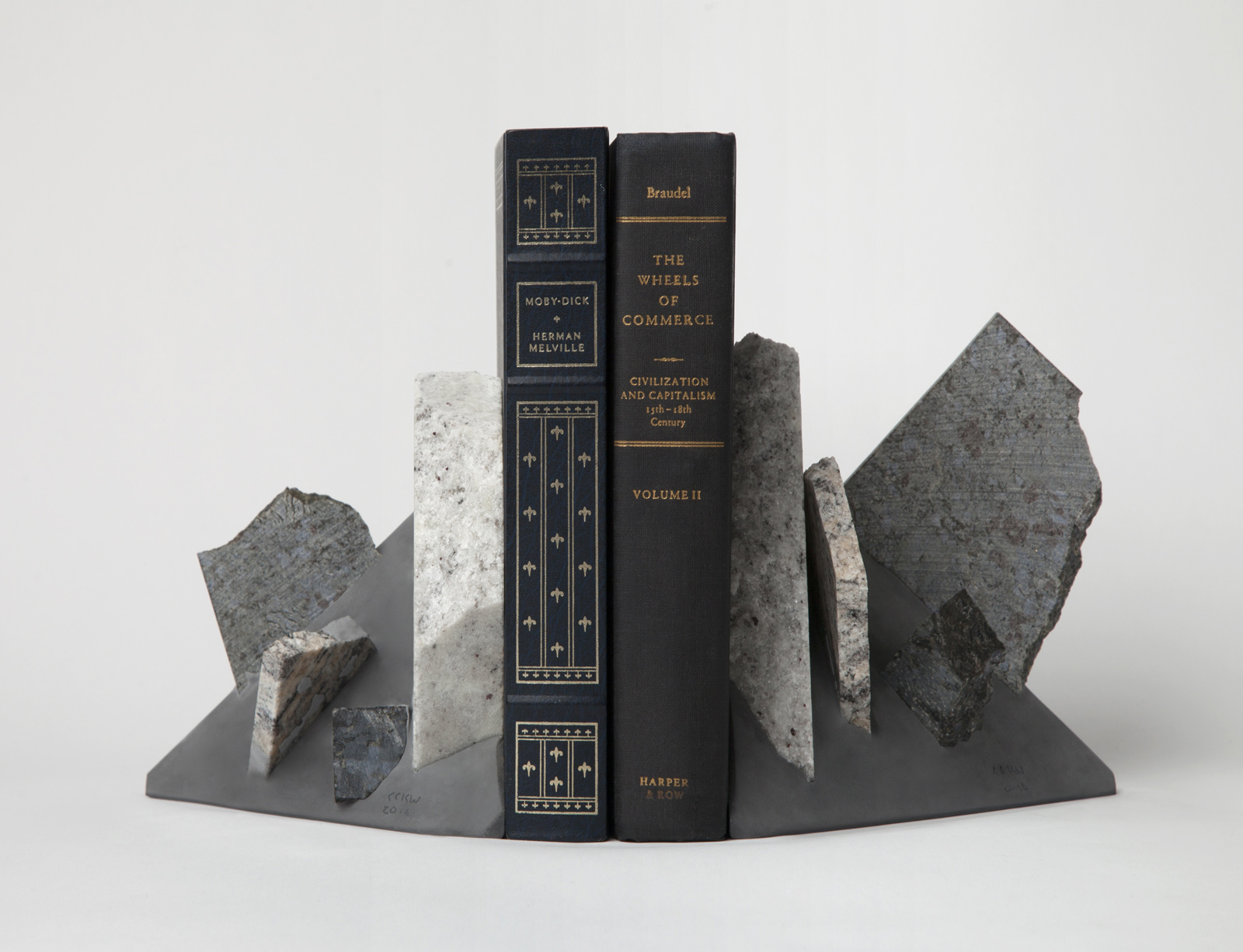 two triangular bookends with rock slices sticking out, two books in between.