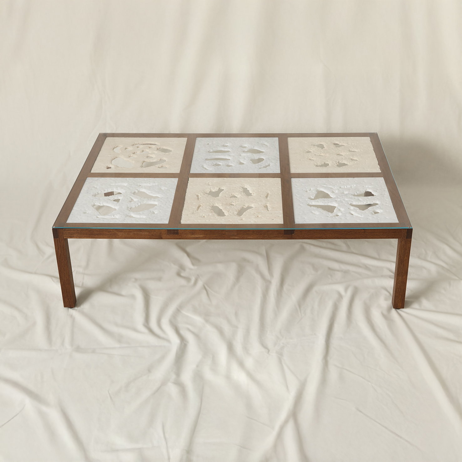 coffee table made from walnut wood frame with marble and travertine squares inset into the surface