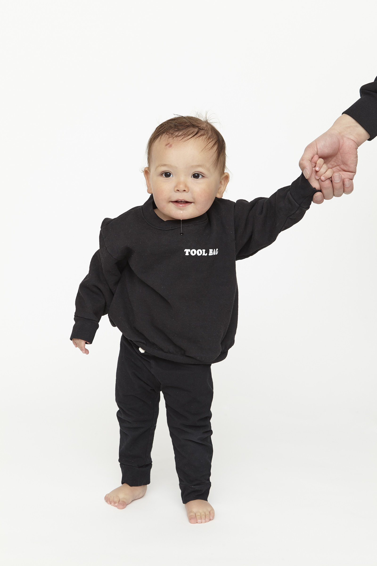 child wearing black sweatshirt with white graphics.