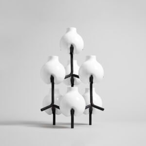 white ceramic small vases held together with a black steel frame.