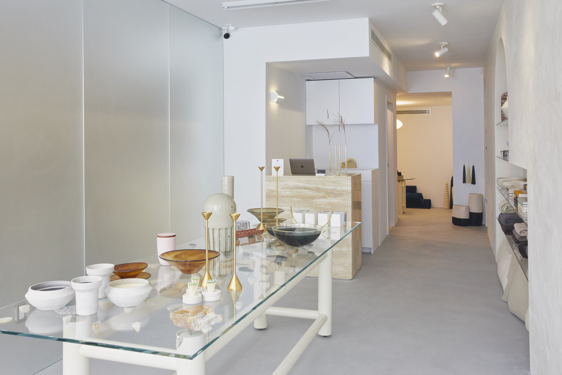 store interior with long floating stone table and goods.