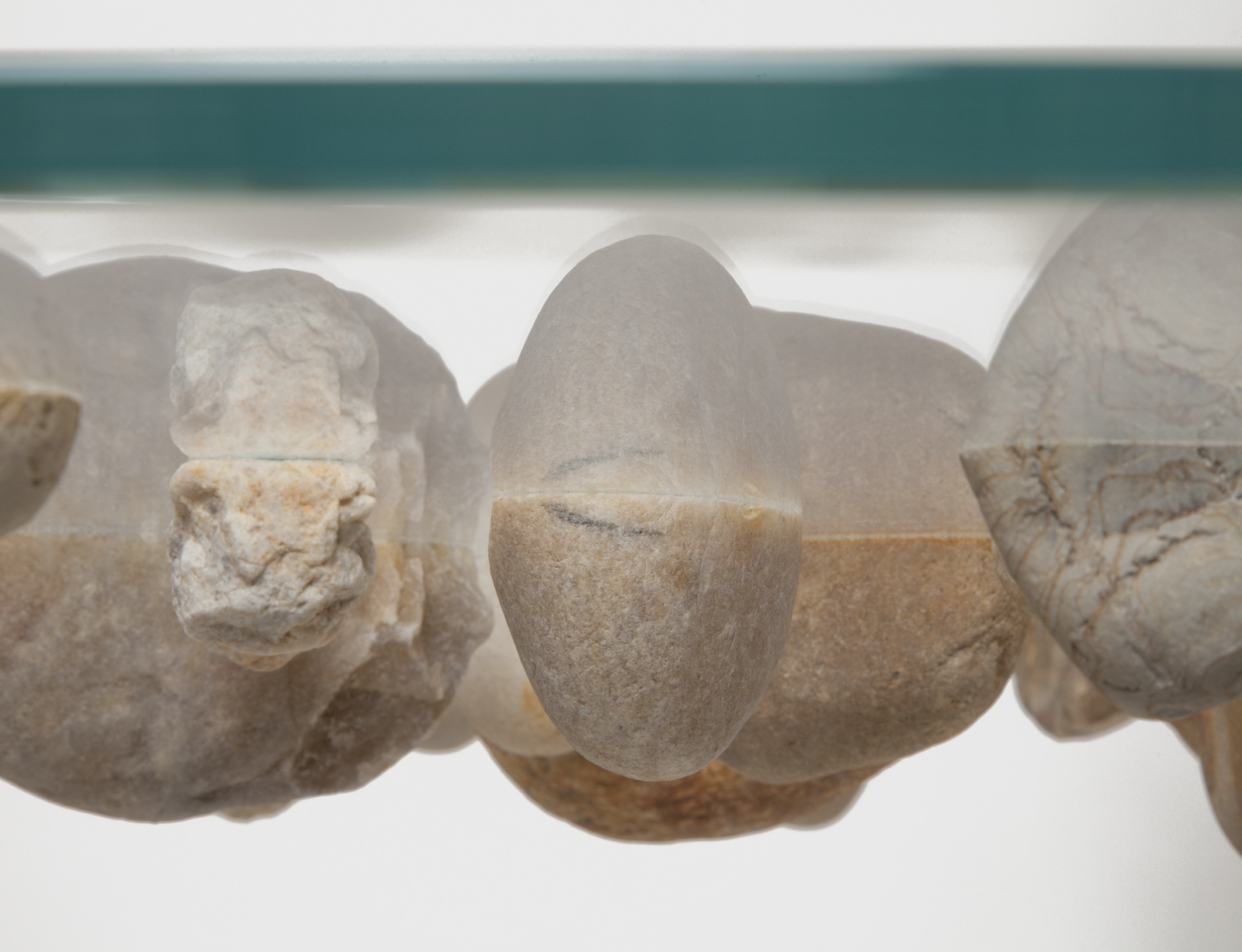 close up of round glass floating stone table with white base.