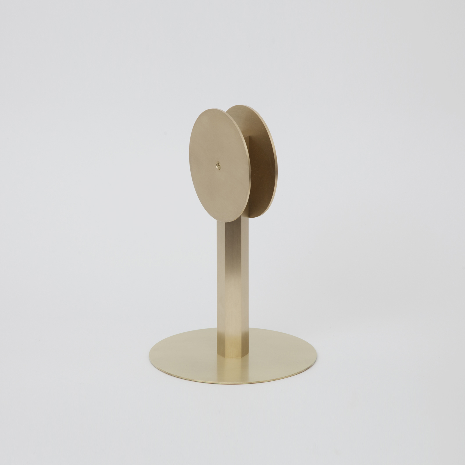 brass circular disk on stand with round base.