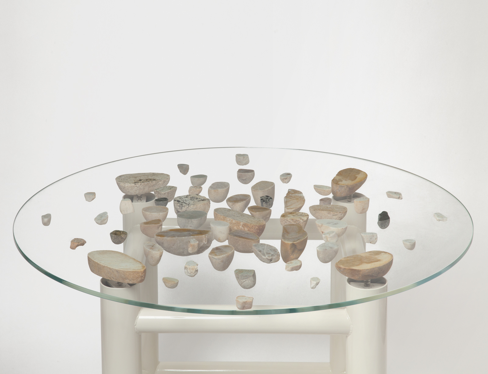 round glass floating stone table with white base.