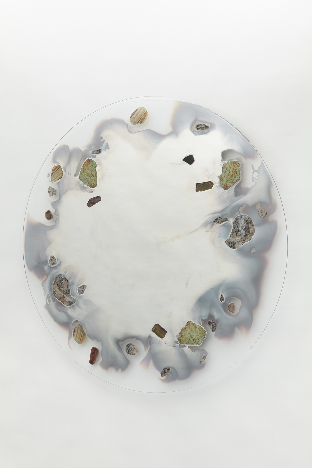 wall mounted circular glass with smoky mirror in center surrounded with various stone slices