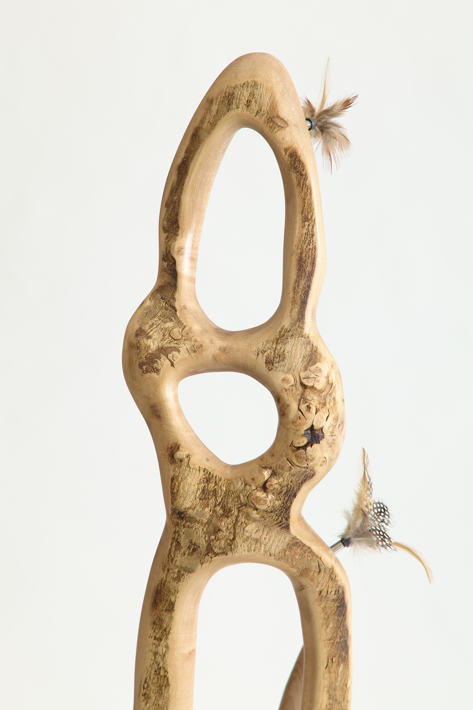 close up of log part of chair with feather decorations