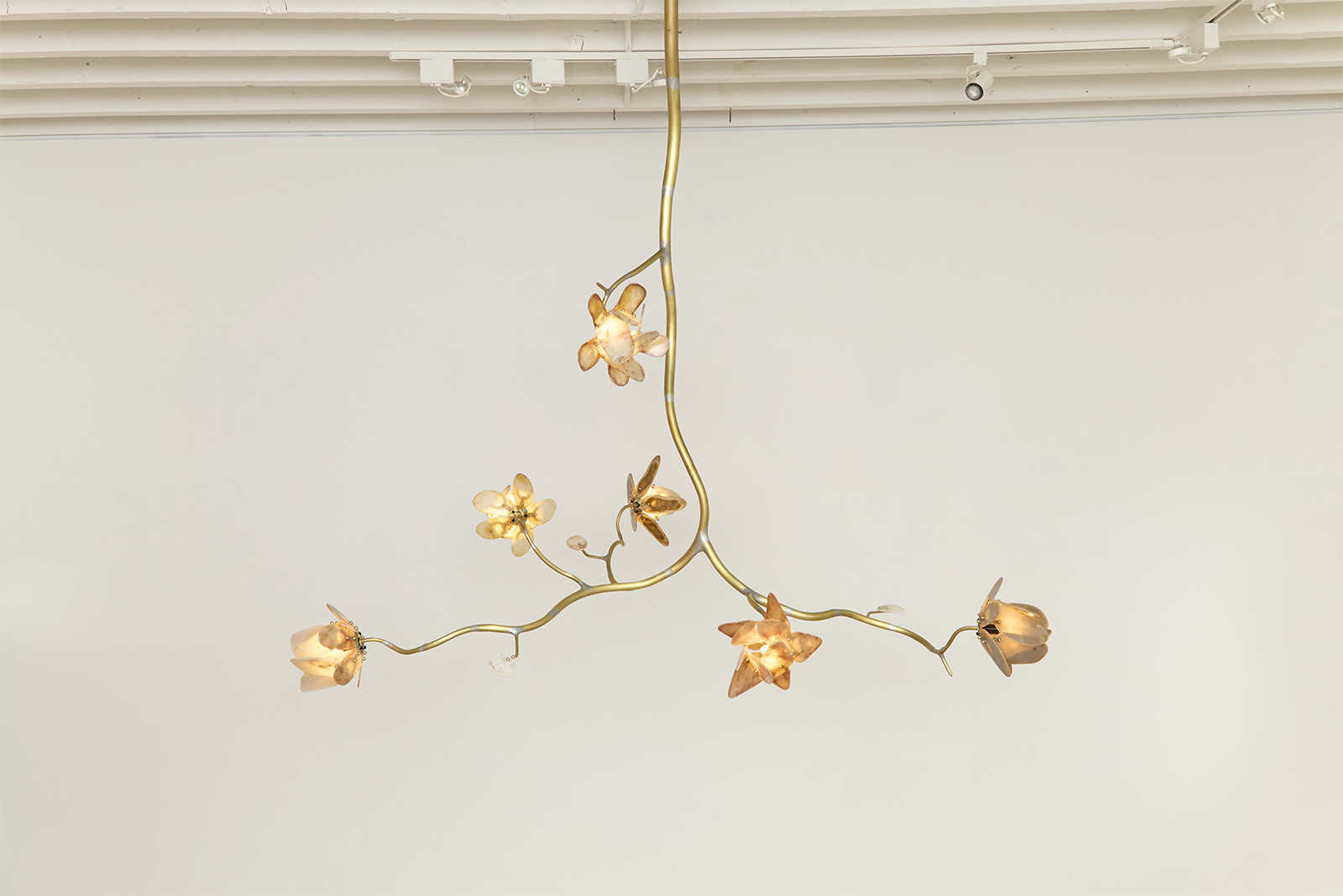 a chandelier of illuminated agate flowers on an organic brass structure