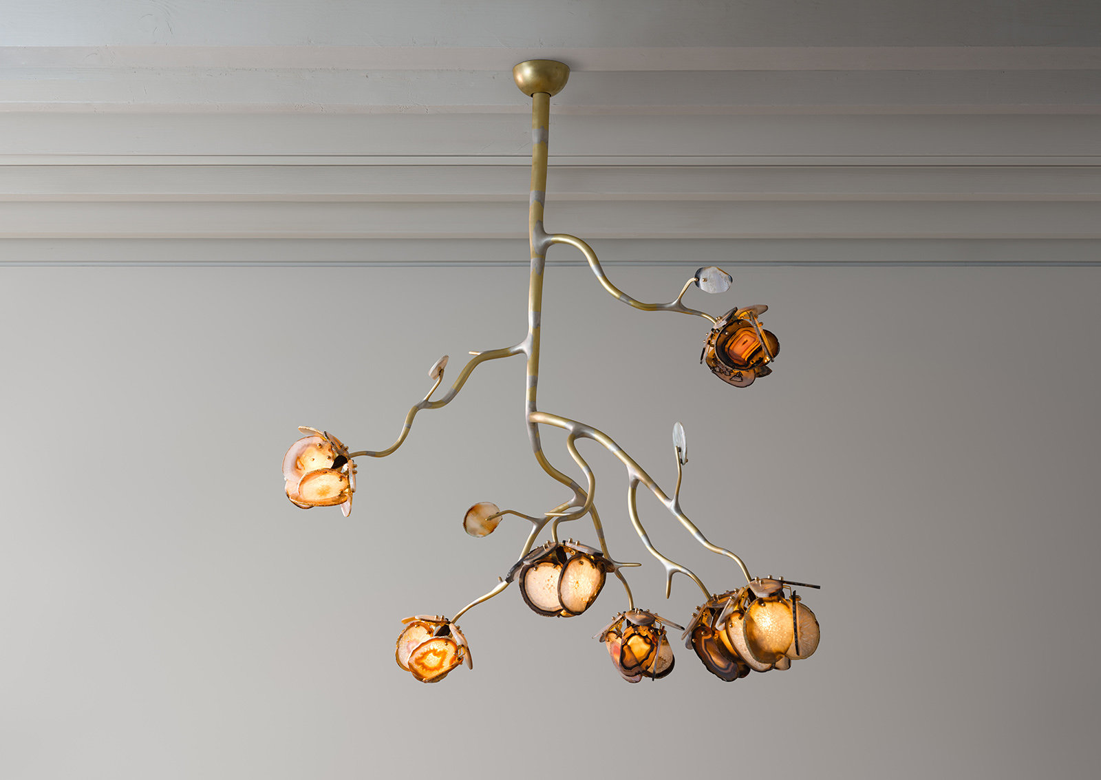 a chandelier made from seven illuminated agate flowers on an organic brass structure