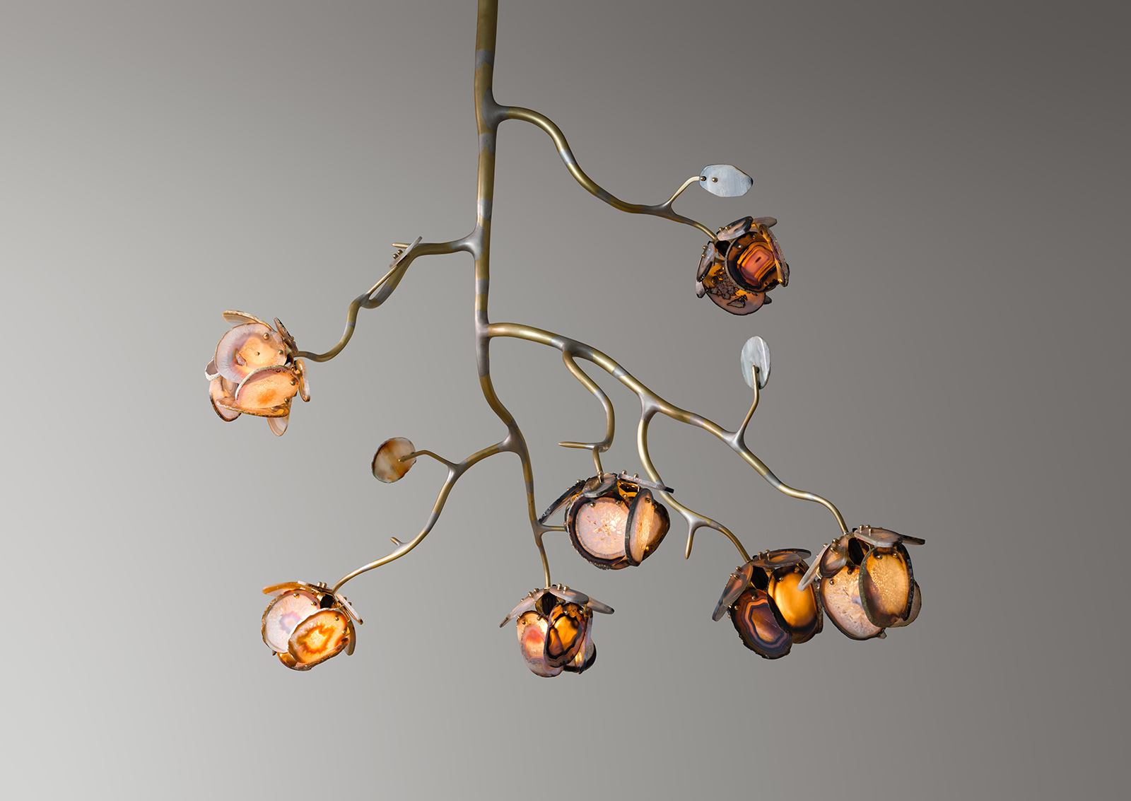 a chandelier made from seven illuminated agate flowers on an organic brass structure