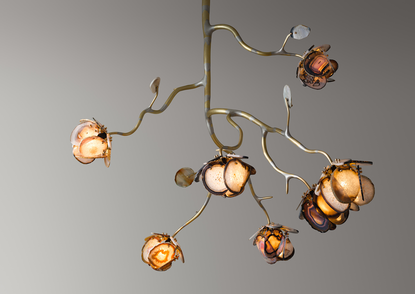 a chandelier made from seven illuminated agate flowers on an organic brass structure