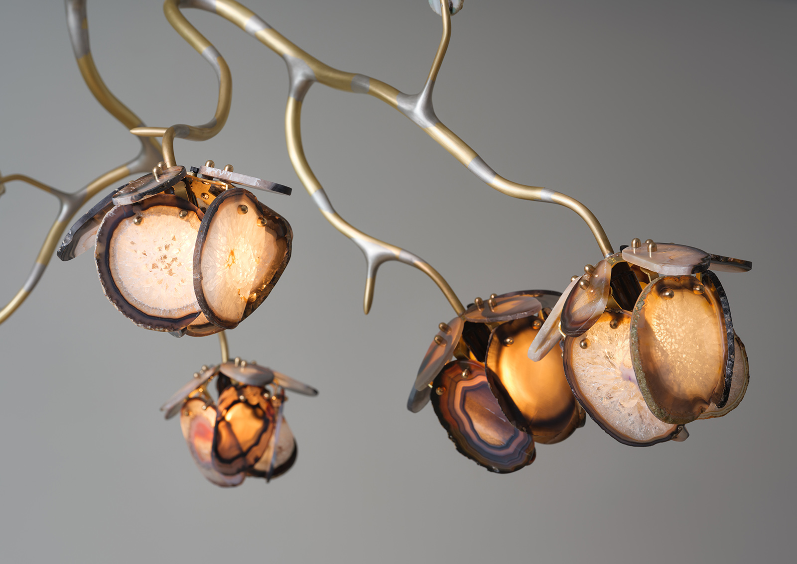 close up of illuminated agate flowers on an organic brass structure