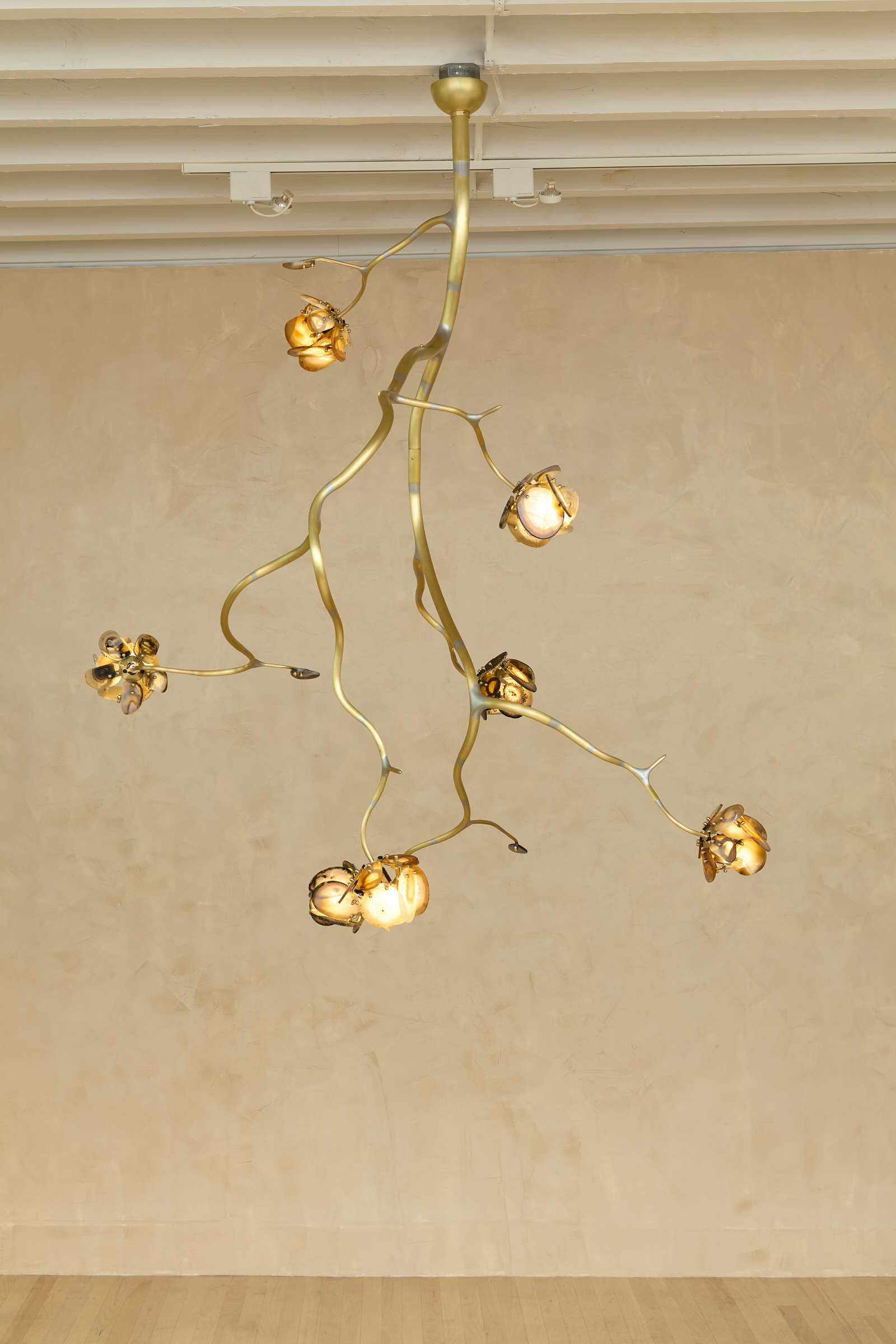 a chandelier of illuminated agate flowers on an organic brass structure