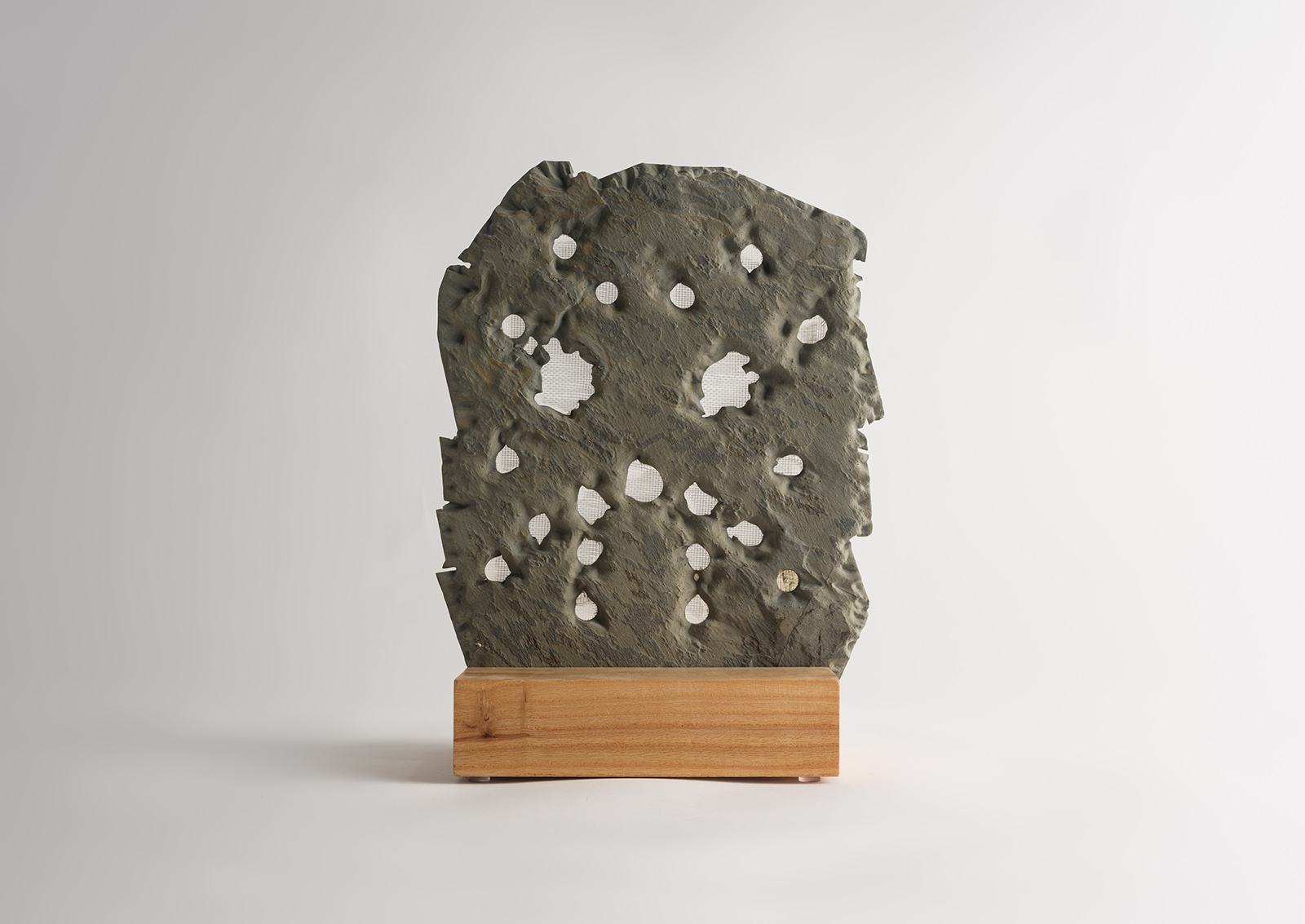 stone hockey mask carved from slate on a wood base