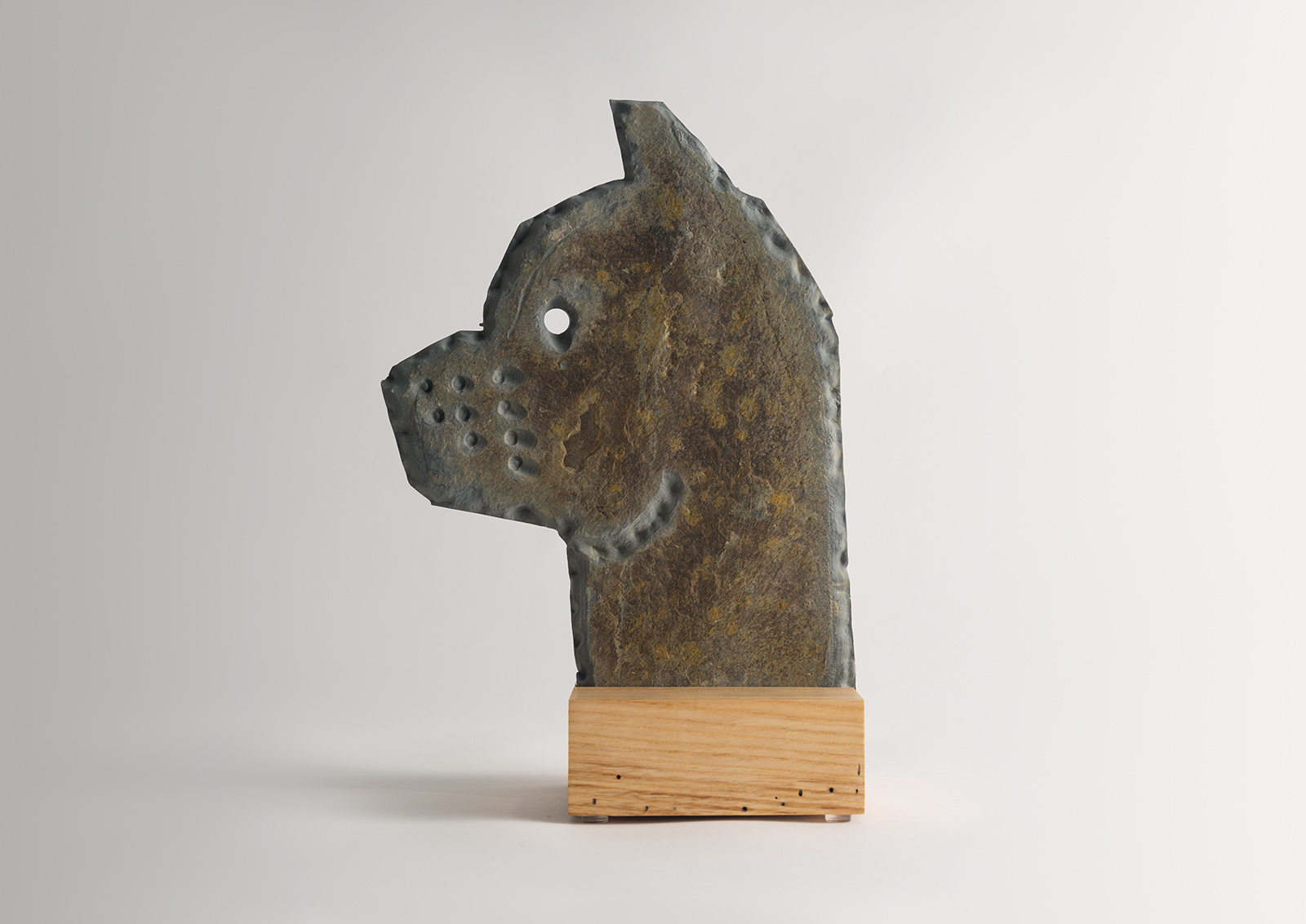 stone dog carved from slate on a wood base