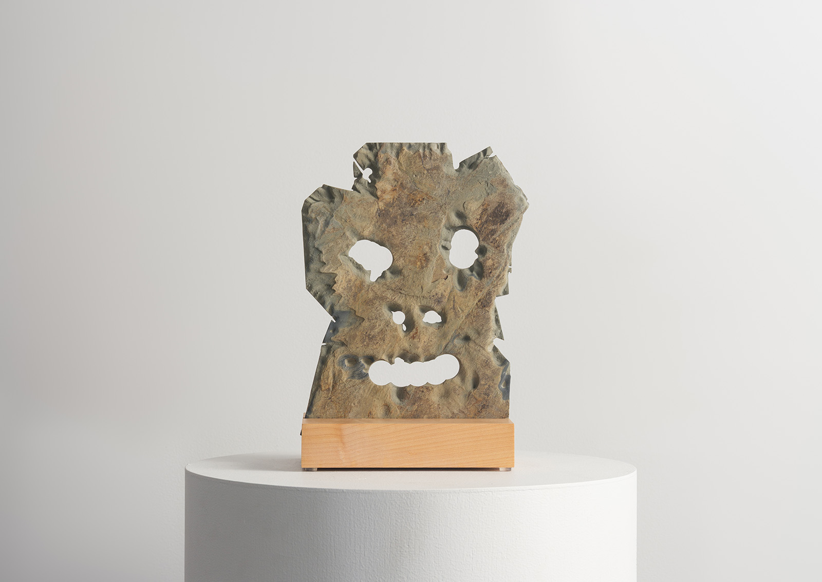 stone mask carved from slate on a wood base