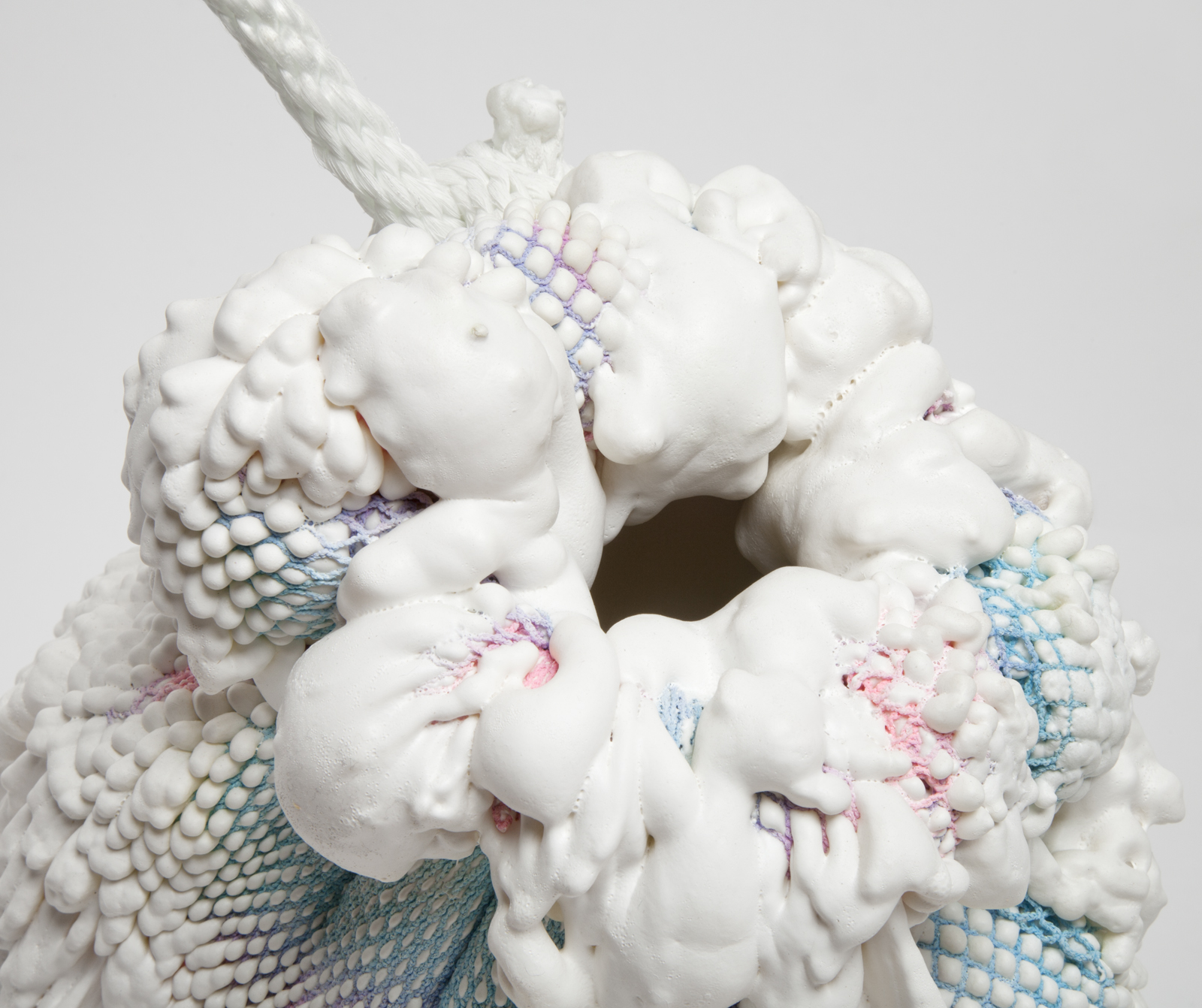 close up of opening of a vase made from gradient spandex with expanding foam extruding out of it