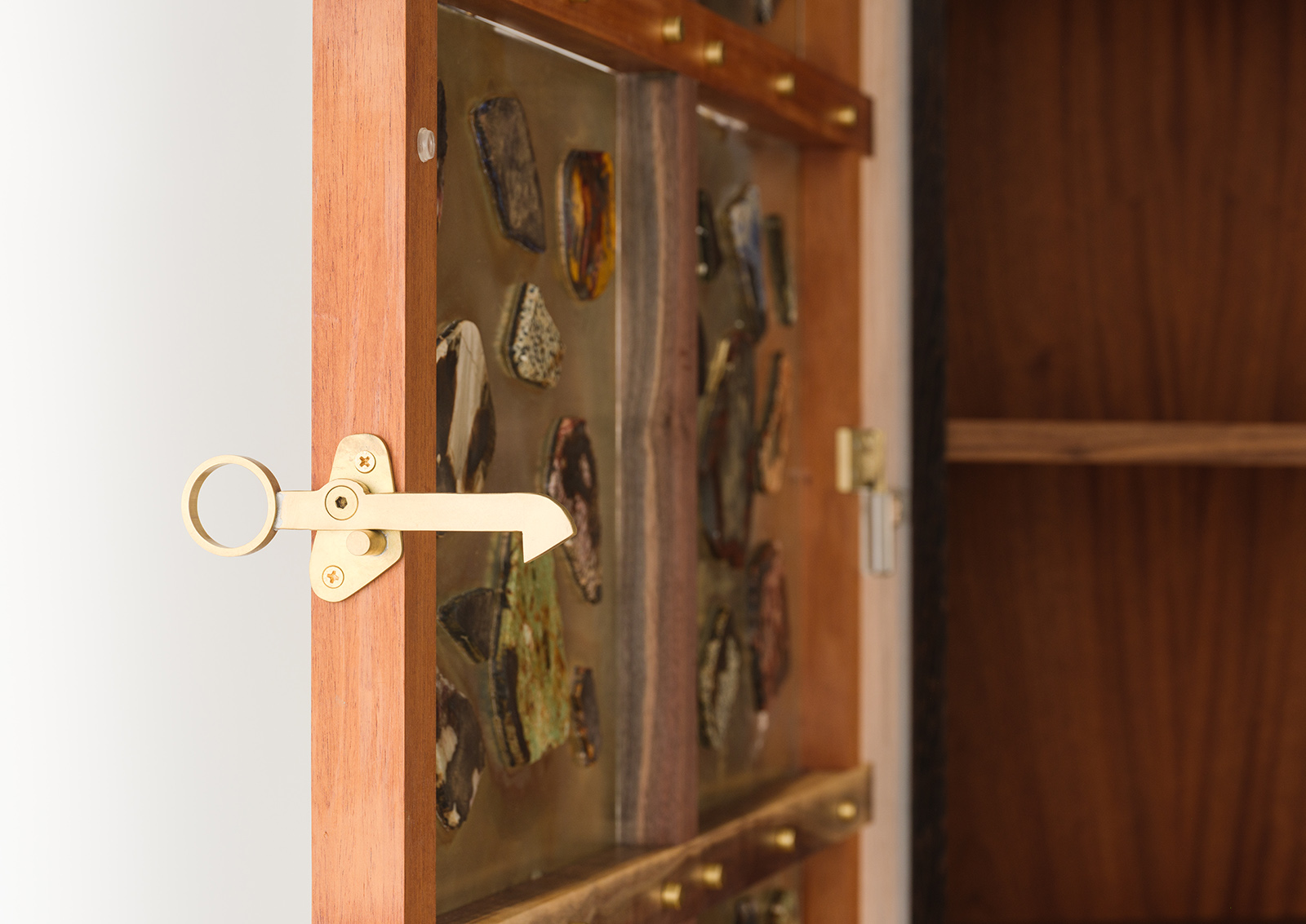detail view of walnut and mahogany wall cabinet with mirrored glass panels with stones glued on