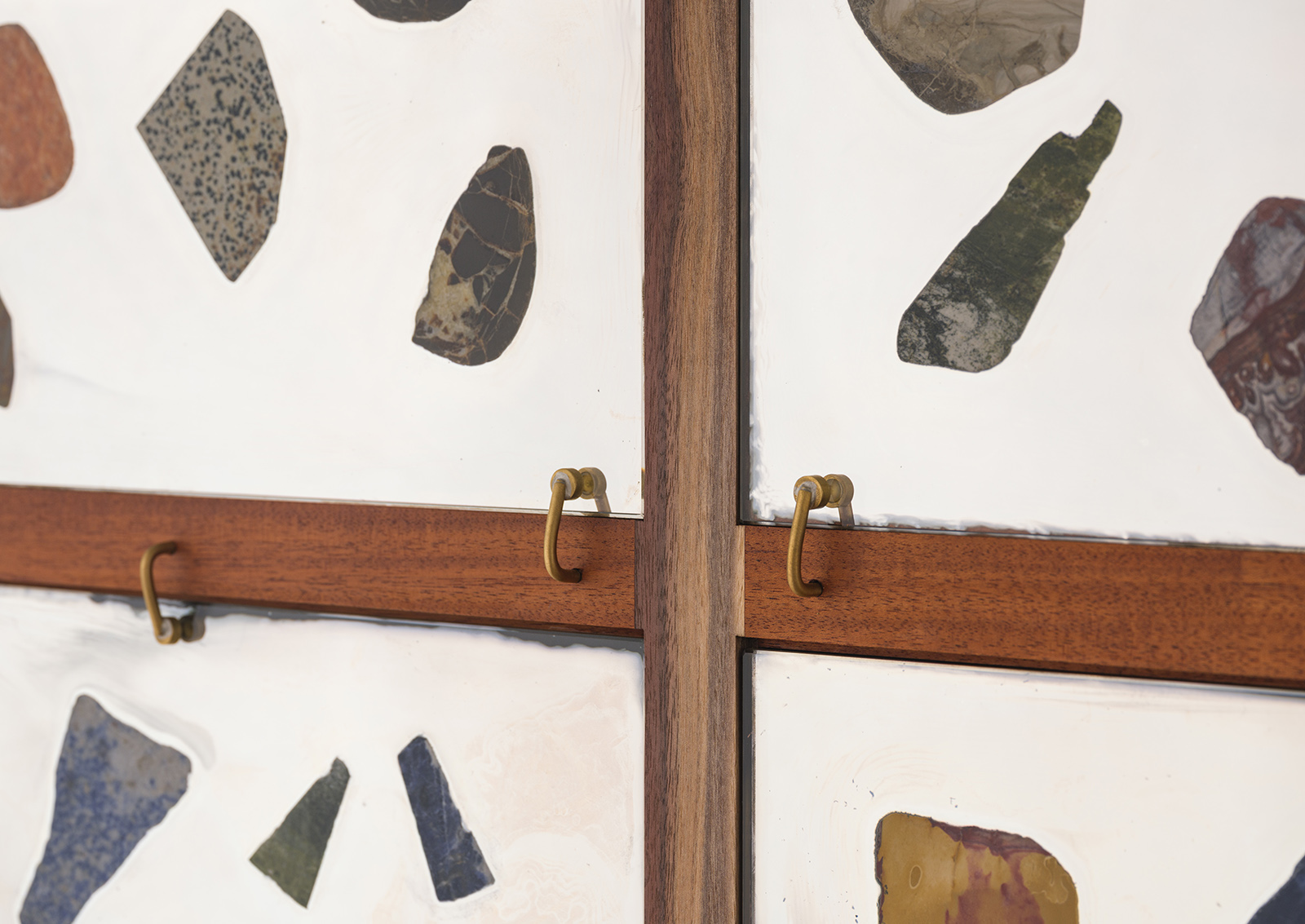 detail view of walnut and mahogany wall cabinet with mirrored glass panels with stones glued on