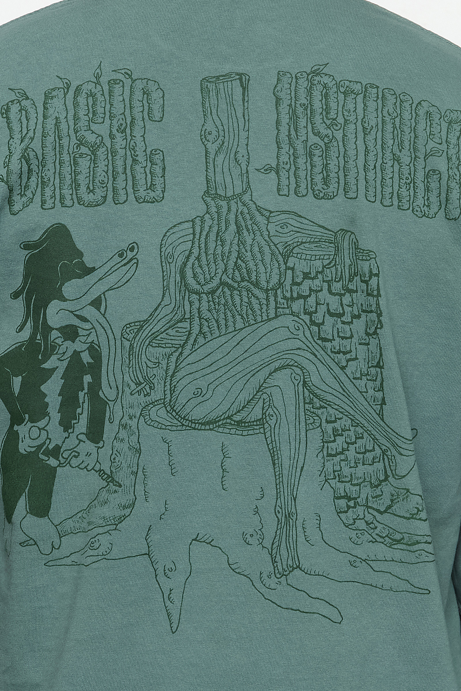 detail of back of shirt with a drawing of a tree woman and a woodpecker with the words "basic instinct"